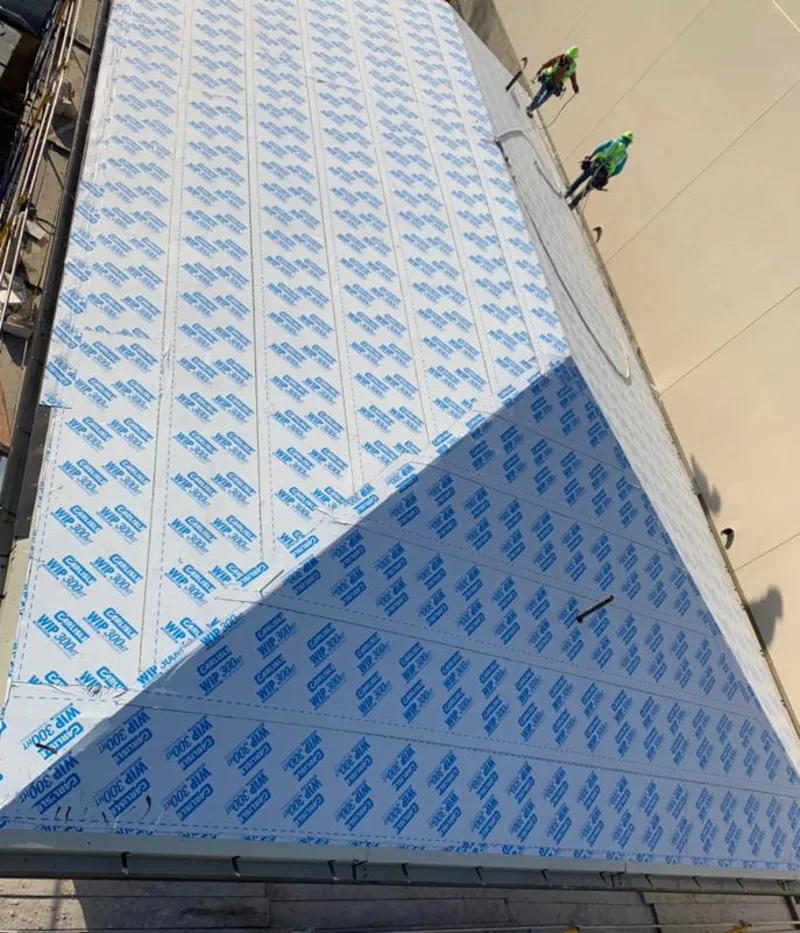 Professional roofers installing underlayment on a metal roof in McFarland